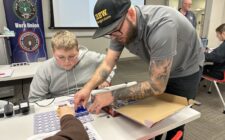 Riley Waters helps a student assemble an electrical circuit board Dec. 19, 2024, after giving a presentation on how students can become electricians through the local IBEW union at Southeastern Community College during its annual 8th Grade Career Fair in West Burlington.